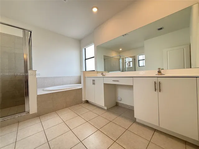 a bathroom with a bathtub sink and mirror