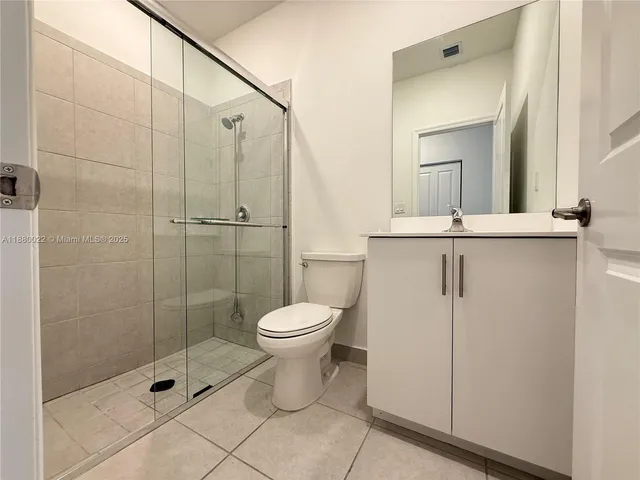 a bathroom with a granite countertop sink a toilet and a mirror