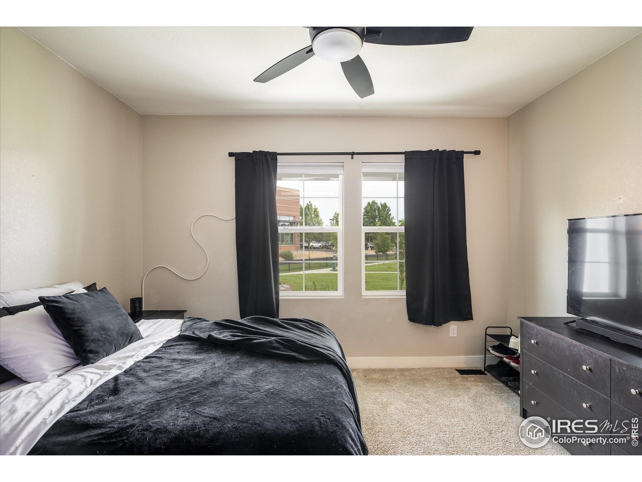 10121 Flower Street Westminster, CO 80021 - Photo 16 of 40 a bedroom with a bed and wooden floor