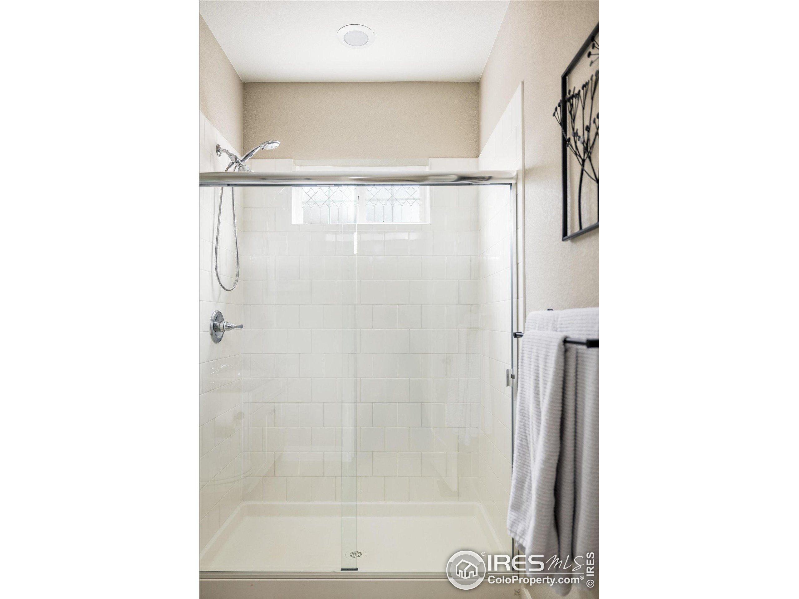 10121 Flower Street Westminster, CO 80021 - Photo 18 of 40 a bathroom with a glass shower door