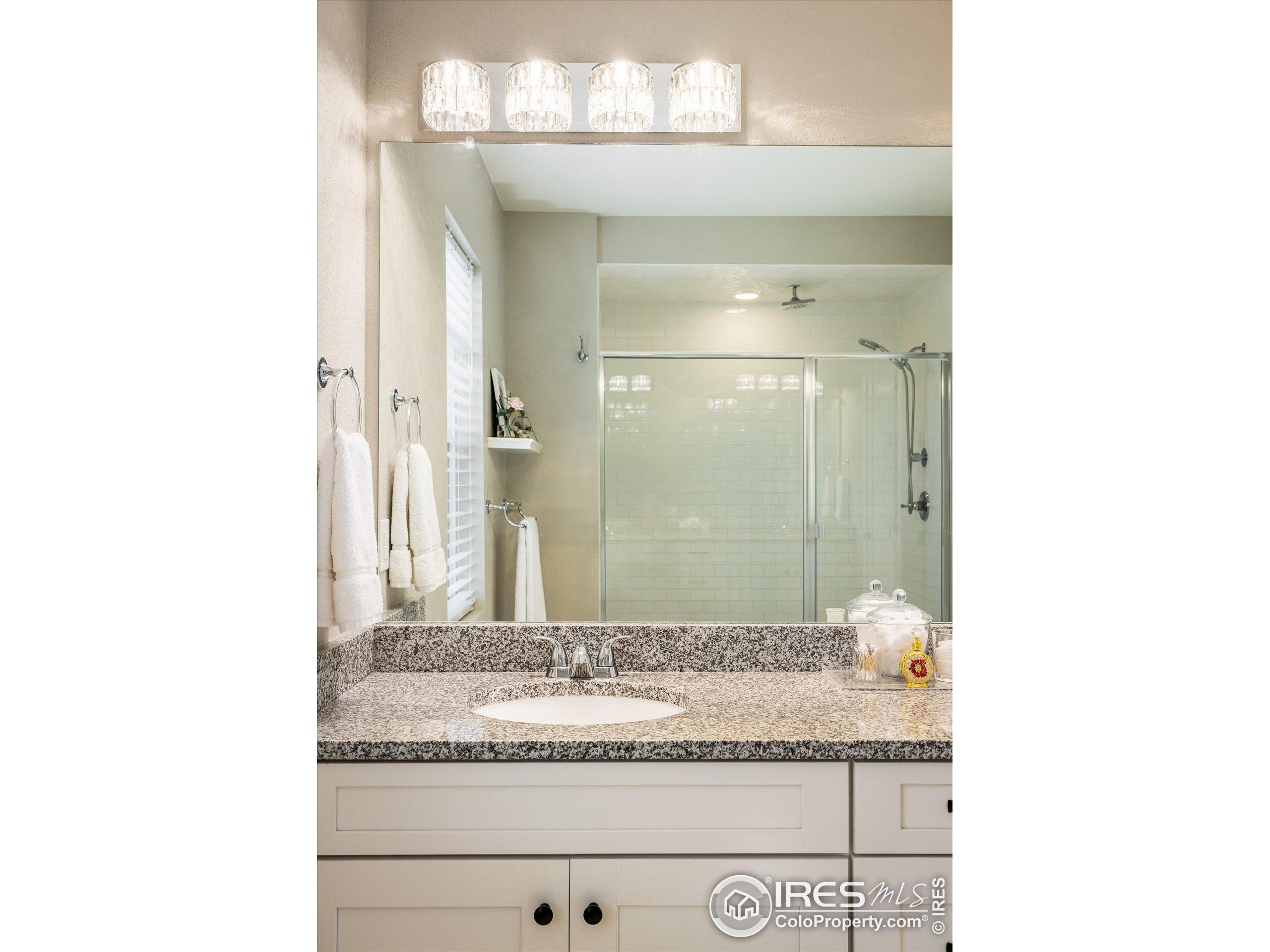10121 Flower Street Westminster, CO 80021 - Photo 22 of 40 a bathroom with a granite countertop sink and a mirror