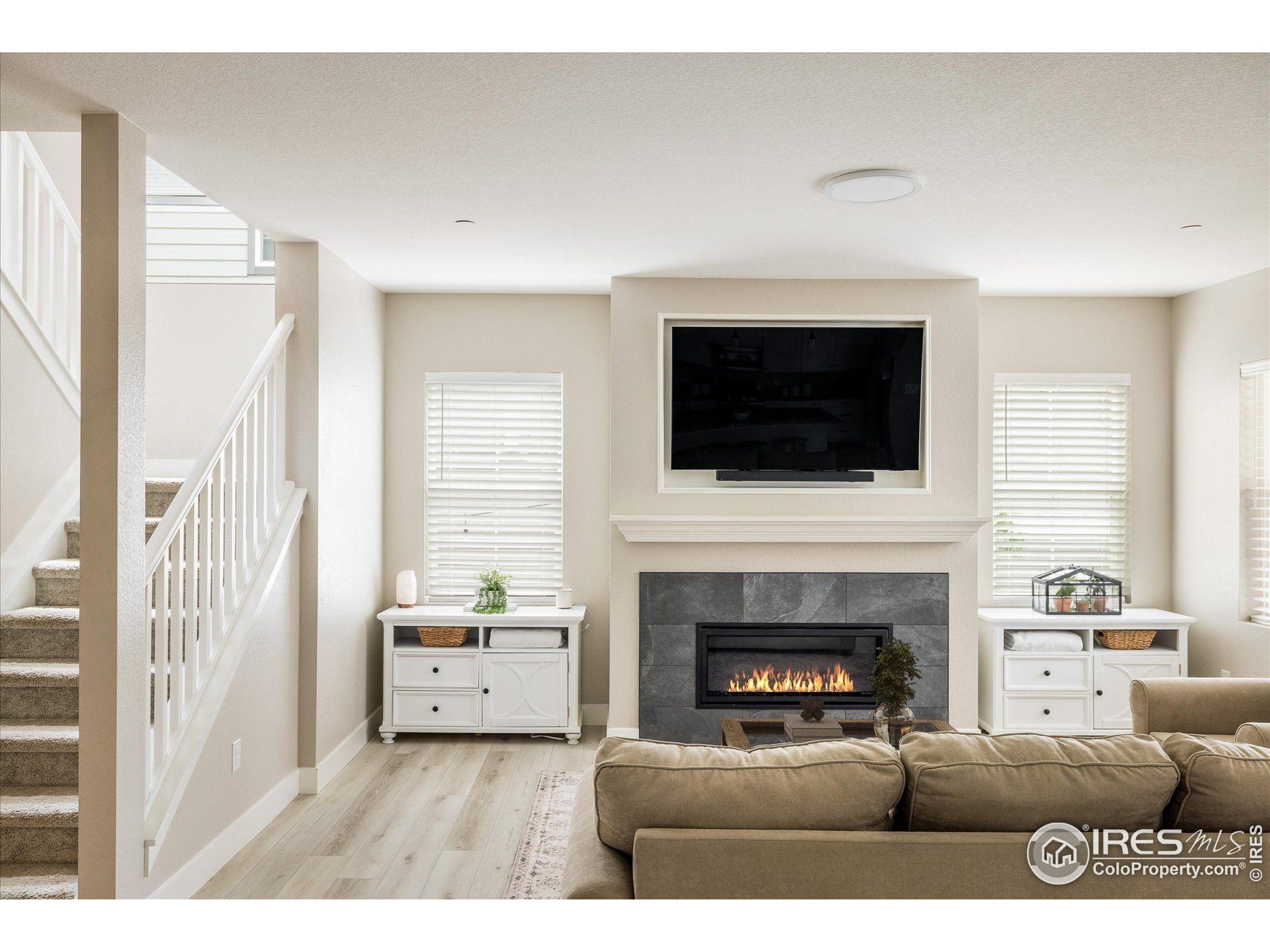 10121 Flower Street Westminster, CO 80021 - Photo 10 of 40 a living room with furniture a fireplace and a flat screen tv