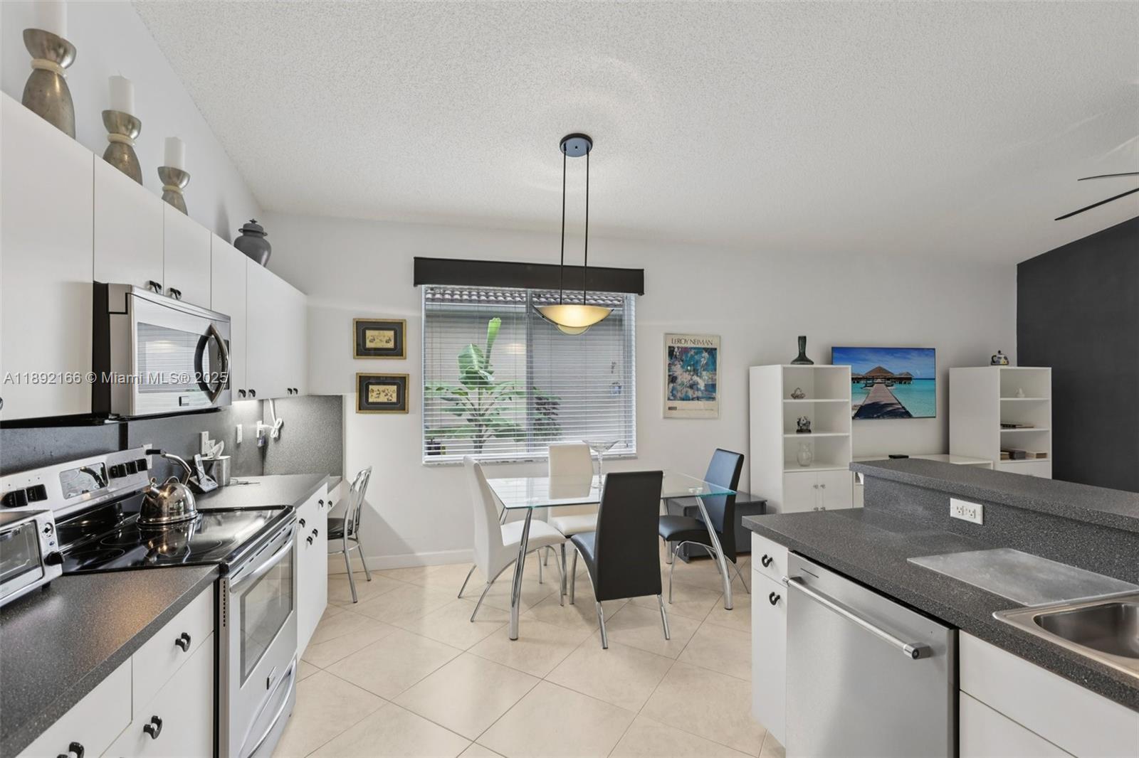8752 Northwest 75th Court Tamarac, FL 33321 - Photo 12 of 26 a kitchen with stainless steel appliances granite countertop a sink stove and refrigerator