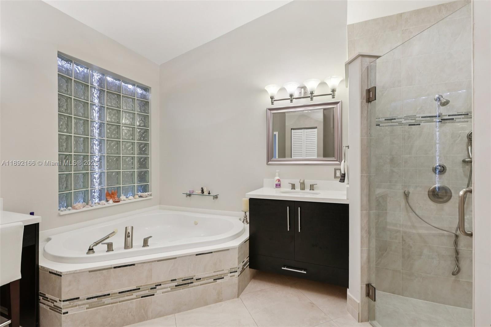 8752 Northwest 75th Court Tamarac, FL 33321 - Photo 16 of 26 a bathroom with a tub sink and mirror