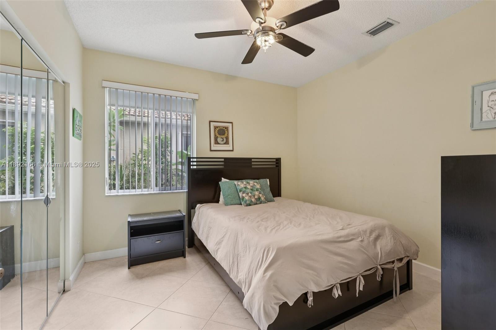 8752 Northwest 75th Court Tamarac, FL 33321 - Photo 19 of 26 a bedroom with a bed and a cabinets