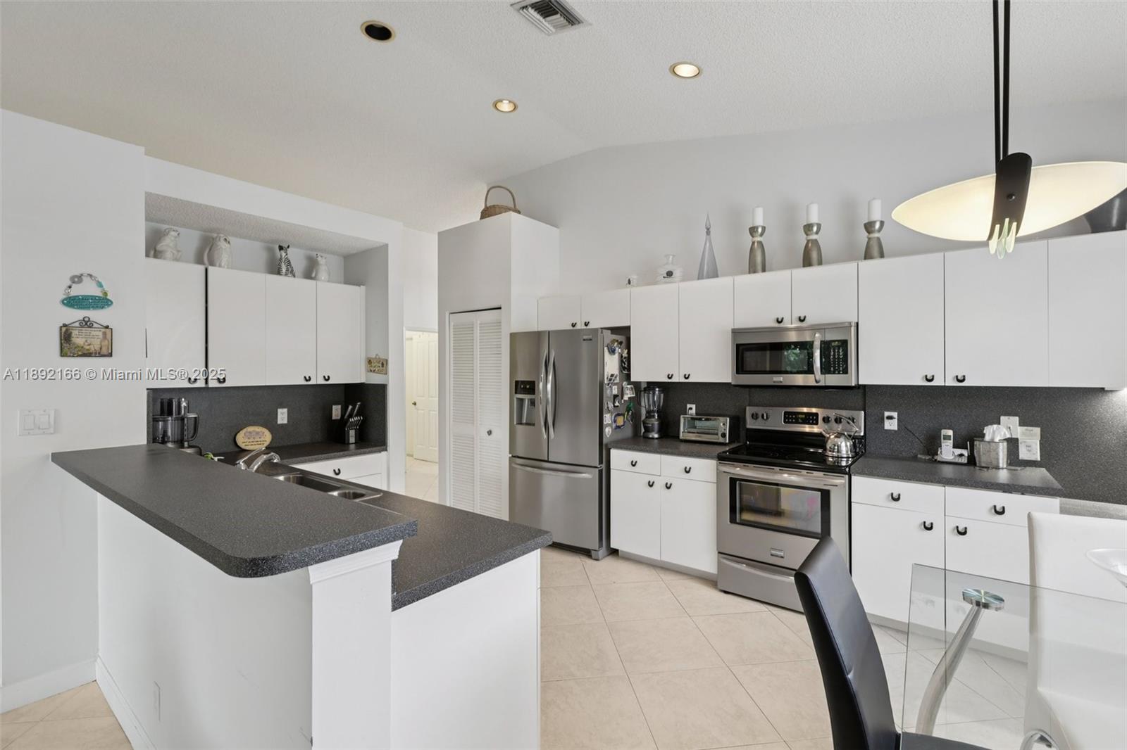 8752 Northwest 75th Court Tamarac, FL 33321 - Photo 2 of 26 a kitchen with stainless steel appliances a stove a sink a microwave a refrigerator a stove and cabinets