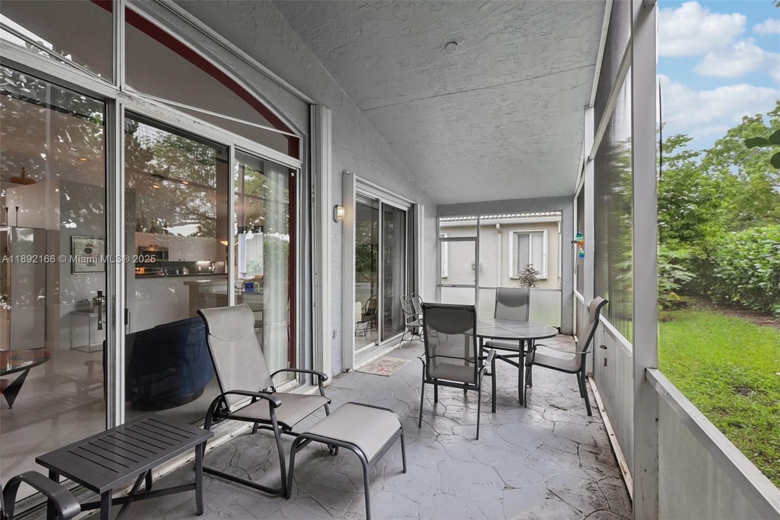 8752 Northwest 75th Court Tamarac, FL 33321 - Photo 25 of 26 a view of a patio with chair and table and chairs with wooden floor and fence