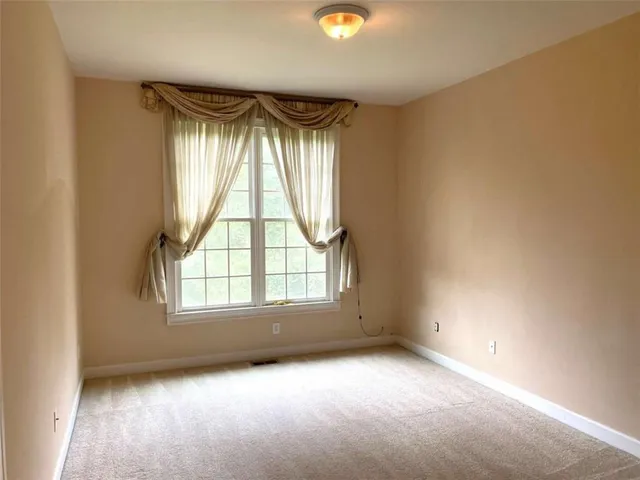 a view of a hallway with wooden floor and windows
