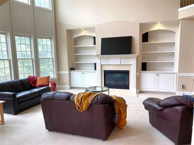 a living room with furniture a flat screen tv and a large window