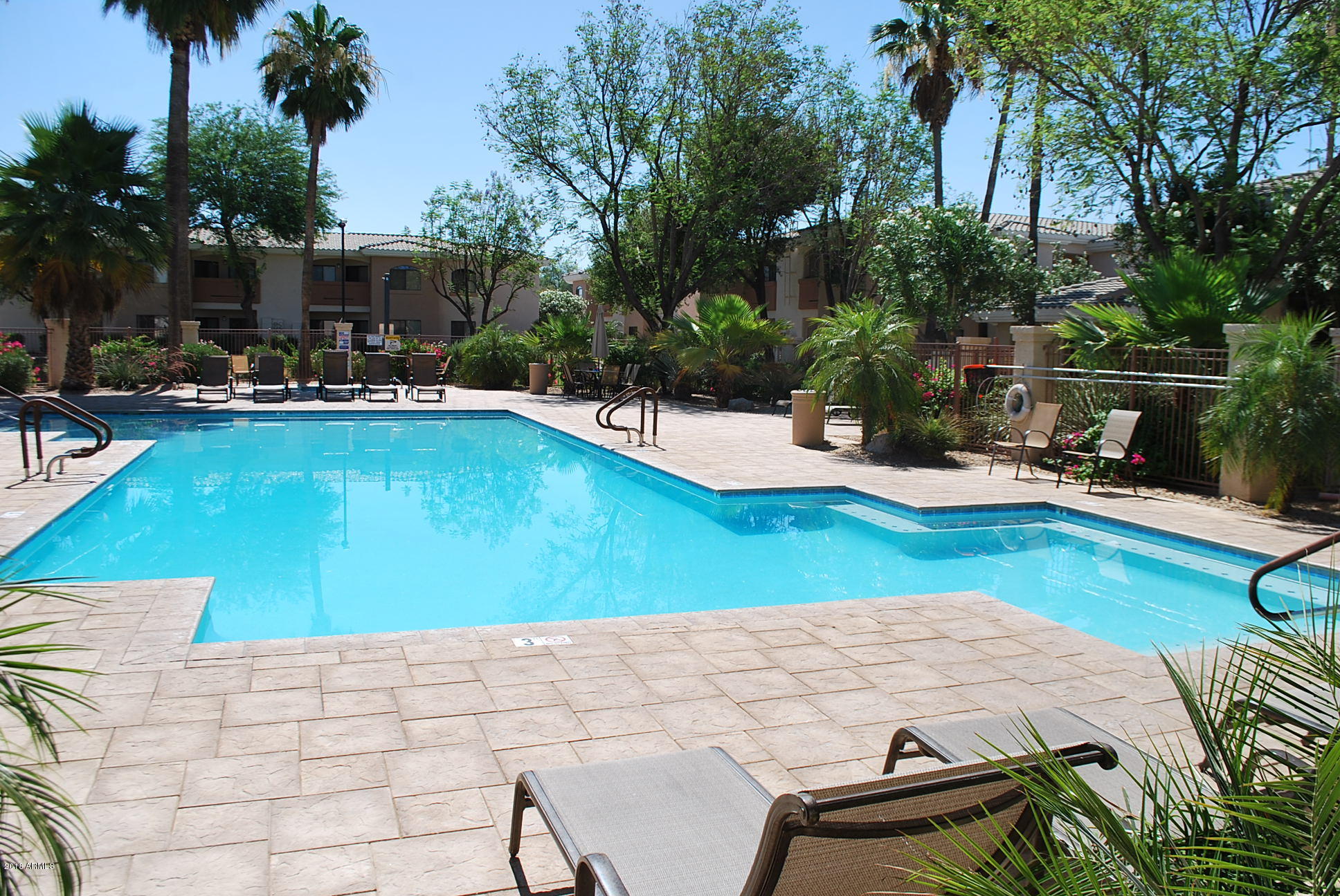10030 West Indian School Road, Unit 158 Phoenix, AZ 85037 - Photo 1 of 28 a view of a swimming pool with lounge chairs