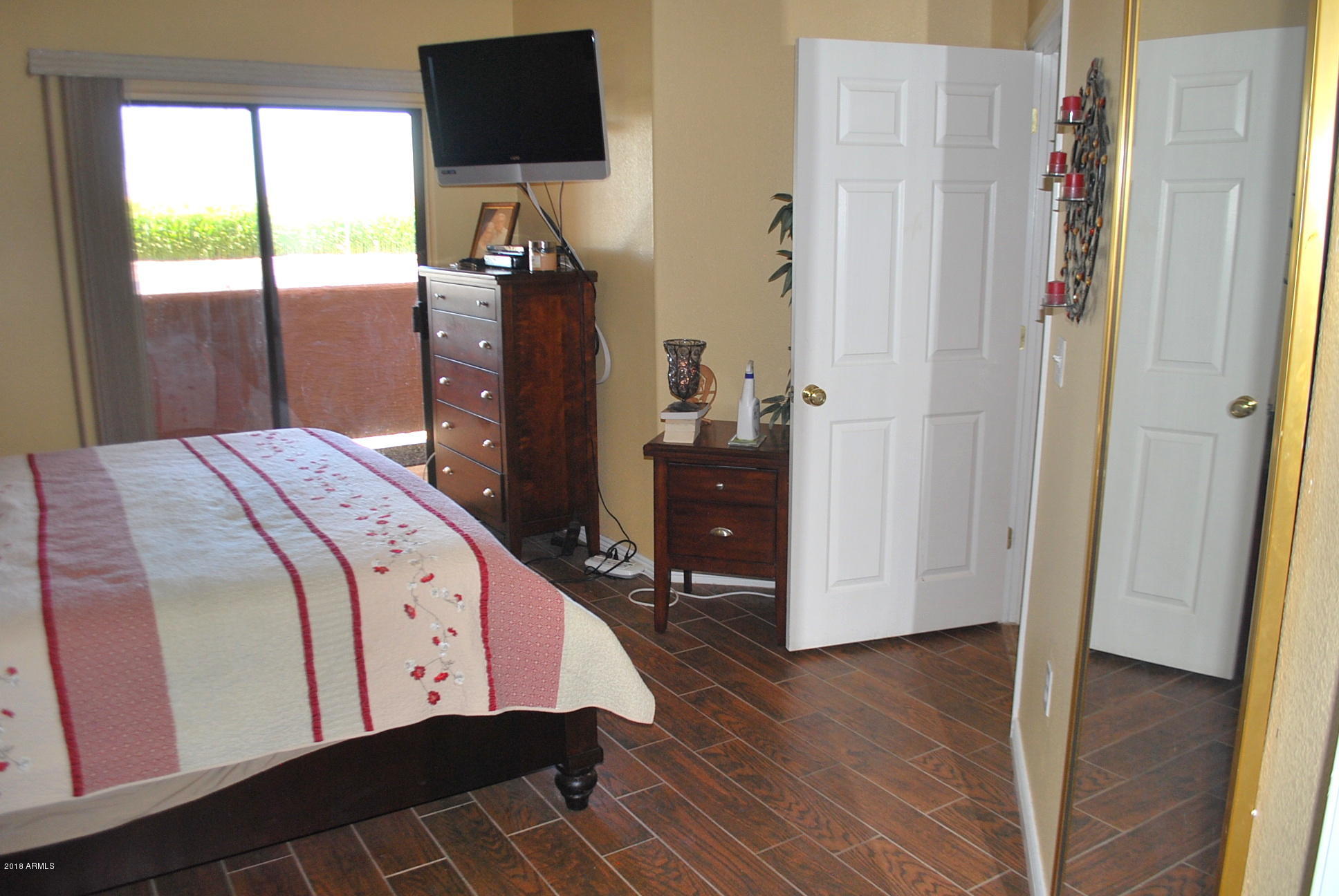 10030 West Indian School Road, Unit 158 Phoenix, AZ 85037 - Photo 14 of 28 a bedroom with a bed and wooden floor