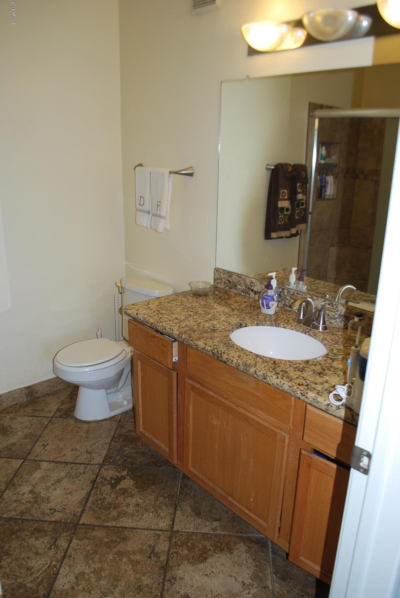 10030 West Indian School Road, Unit 158 Phoenix, AZ 85037 - Photo 16 of 28 a bathroom with a granite countertop sink a toilet and a mirror