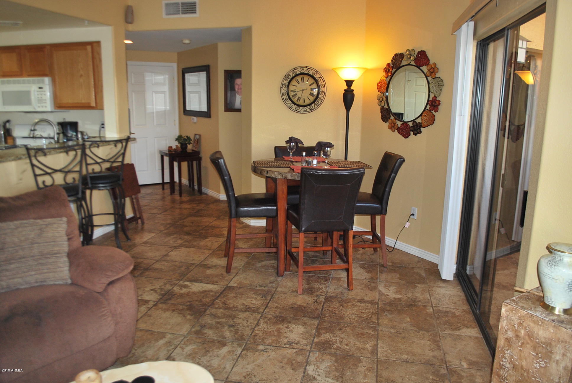 10030 West Indian School Road, Unit 158 Phoenix, AZ 85037 - Photo 4 of 28 a view of a dining room and livingroom furniture wooden floor a rug and a chandelier