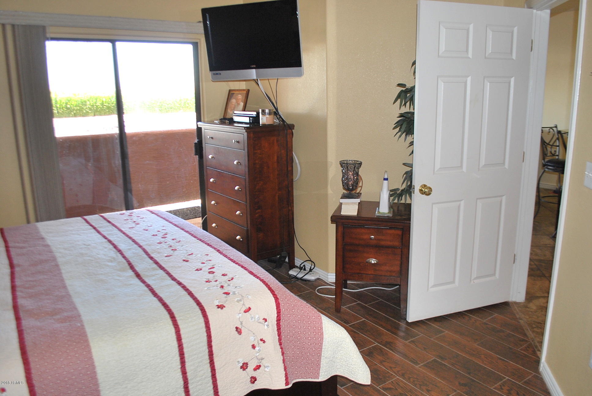 10030 West Indian School Road, Unit 158 Phoenix, AZ 85037 - Photo 7 of 28 a bedroom with a bed and flat screen tv