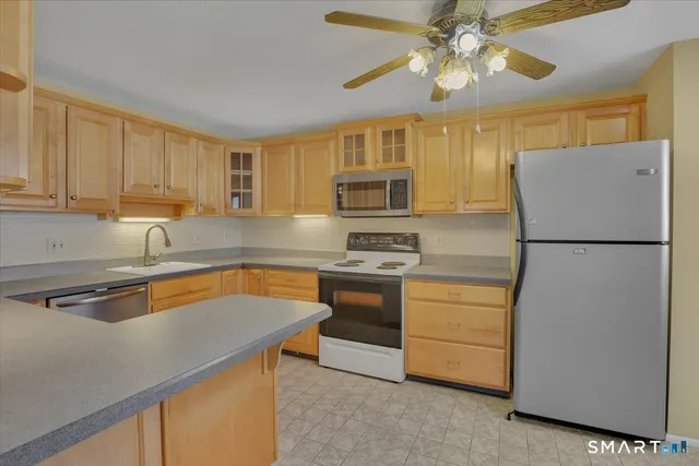 a kitchen with stainless steel appliances granite countertop a refrigerator a stove top oven a sink and dishwasher