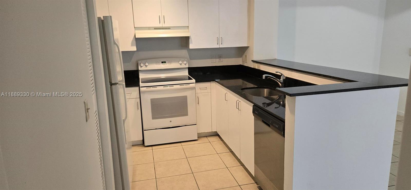 2173 Renaissance Boulevard, Unit 103 Miramar, FL 33025 - Photo 16 of 36 a kitchen with a refrigerator and white cabinets