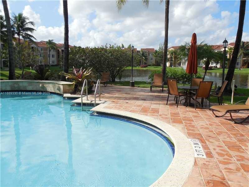 2173 Renaissance Boulevard, Unit 103 Miramar, FL 33025 - Photo 31 of 36 a view of a swimming pool with a lounge chairs