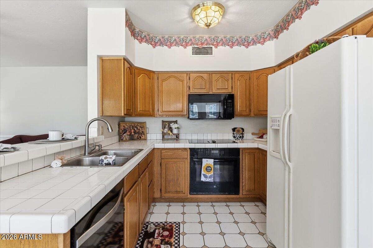 1919 East Clipper Court Gilbert, AZ 85234 - Photo 19 of 62 a kitchen with stainless steel appliances granite countertop a sink a stove a refrigerator cabinets and living room view
