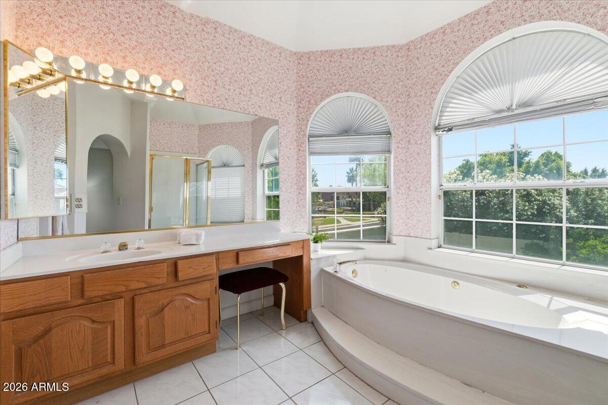 1919 East Clipper Court Gilbert, AZ 85234 - Photo 29 of 62 a spacious bathroom with a granite countertop tub a double vanity sink a window and a mirror