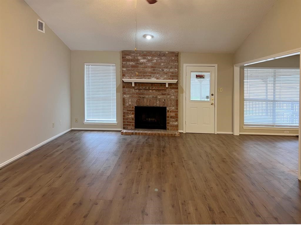 3122 Windmill Street Sugar Land, TX 77479 - Photo 2 of 13 an empty room with wooden floor fireplace and windows