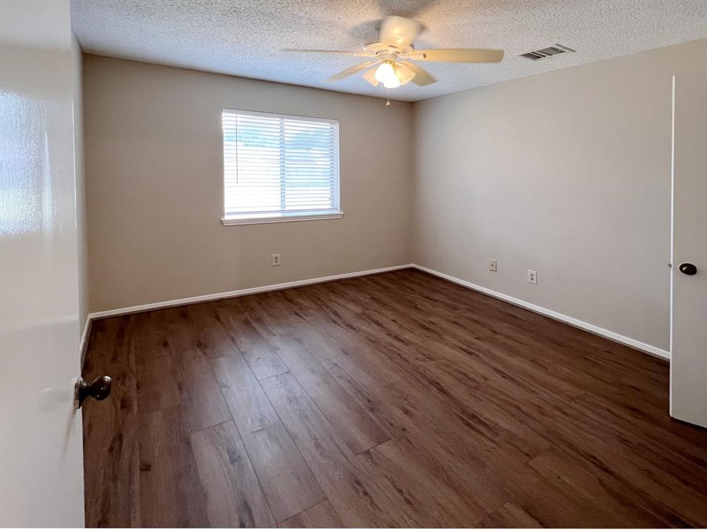 3122 Windmill Street Sugar Land, TX 77479 - Photo 8 of 13 an empty room with wooden floor chandelier fan and windows