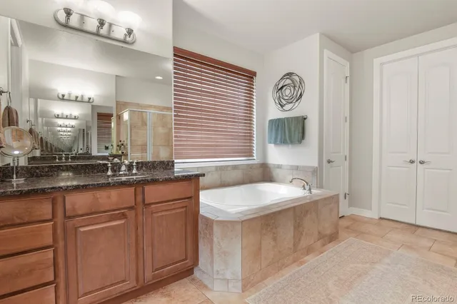 a spacious bathroom with sinks mirror and a bathtub