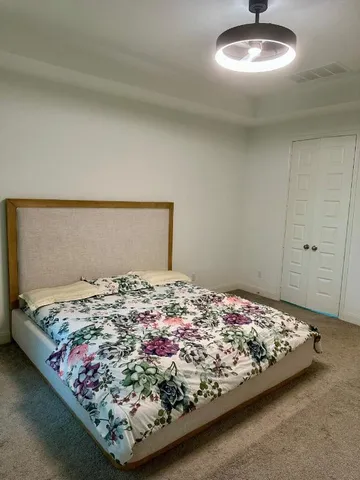 a bed sitting in a bedroom next to a window