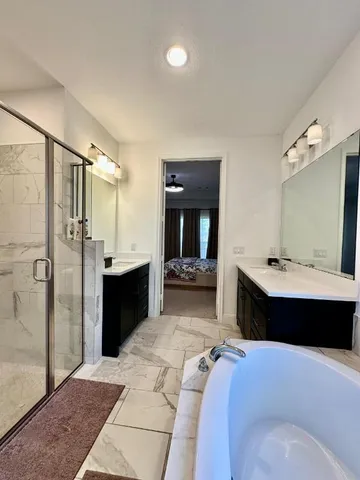 a large bedroom with a bed and a view of living room