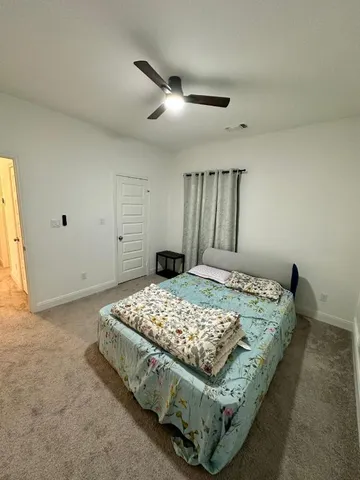 a bed sitting in a spacious bedroom next to a window