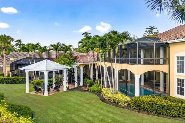 an aerial view of a residential houses with outdoor space and trees