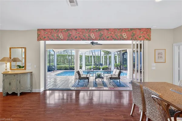 a living room with furniture large window and wooden floor