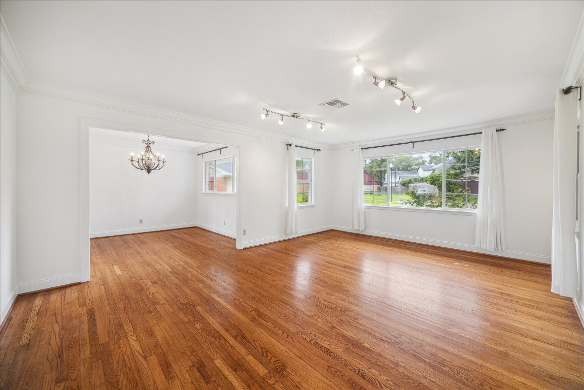 10 Pom Court Spring Valley Village, TX 77055 - Photo 11 of 27 an empty room with wooden floor chandelier and windows