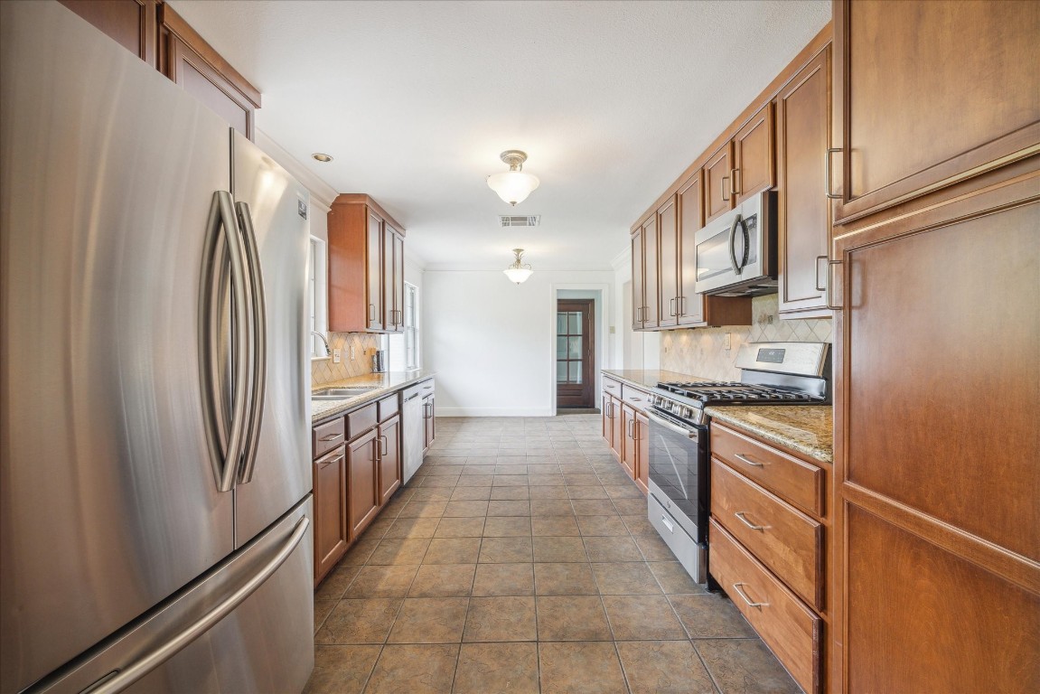 10 Pom Court Spring Valley Village, TX 77055 - Photo 12 of 27 a large kitchen with stainless steel appliances granite countertop a refrigerator and a stove top oven