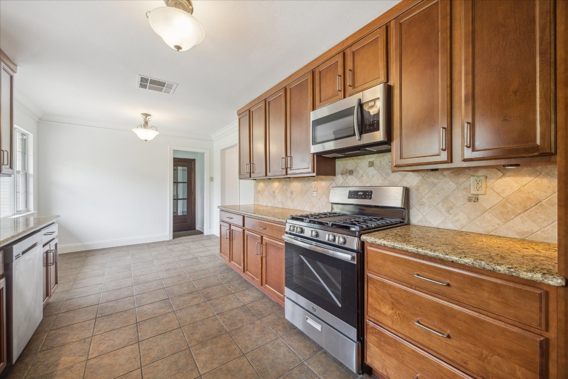 10 Pom Court Spring Valley Village, TX 77055 - Photo 15 of 27 a kitchen with stainless steel appliances granite countertop a stove a sink and a microwave