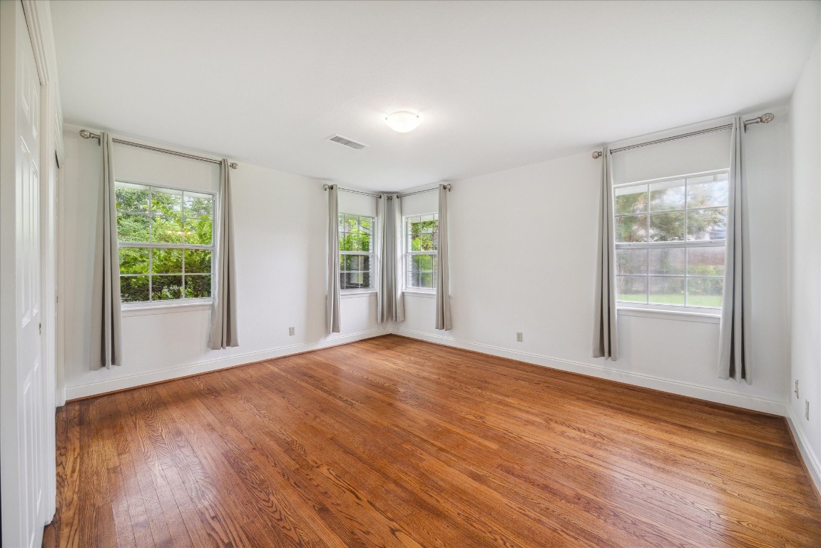 10 Pom Court Spring Valley Village, TX 77055 - Photo 19 of 27 a view of an empty room with wooden floor and a window
