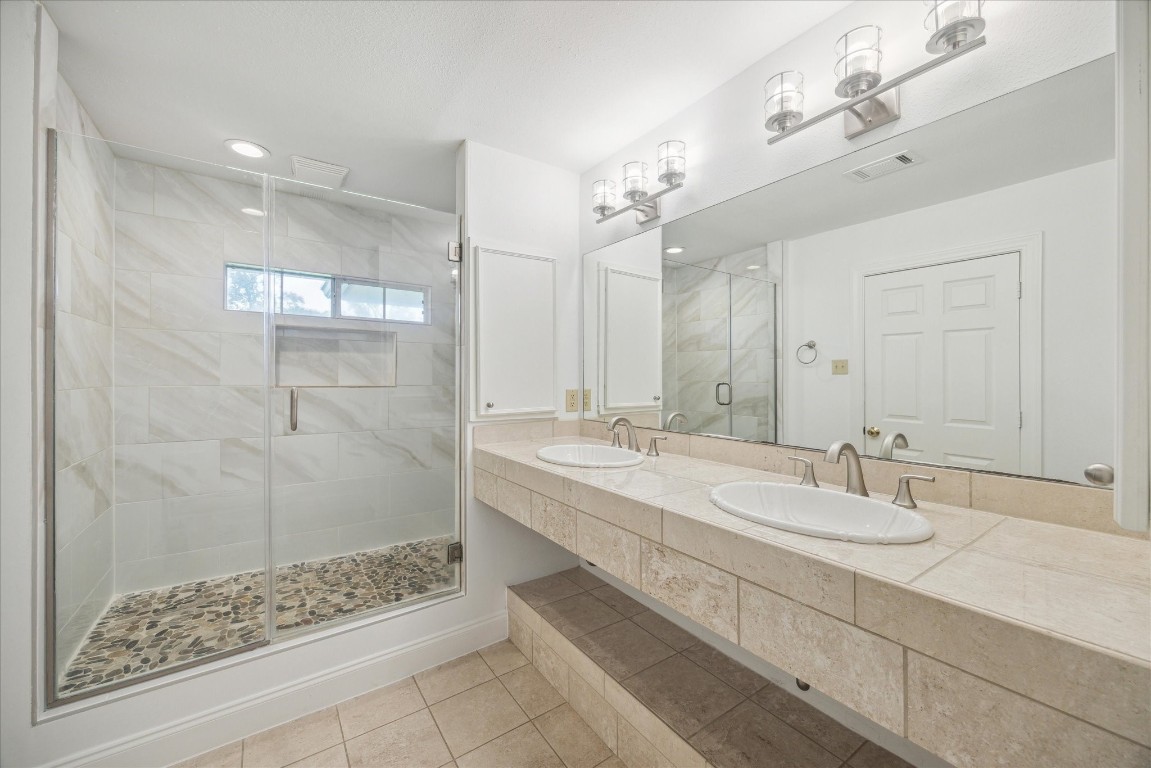 10 Pom Court Spring Valley Village, TX 77055 - Photo 21 of 27 a bathroom with a double vanity sink mirror and shower