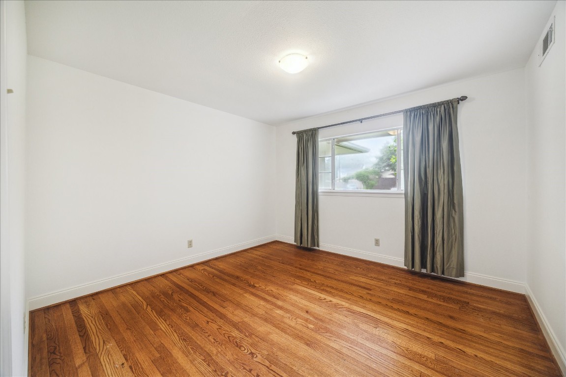 10 Pom Court Spring Valley Village, TX 77055 - Photo 23 of 27 an empty room with wooden floor and windows