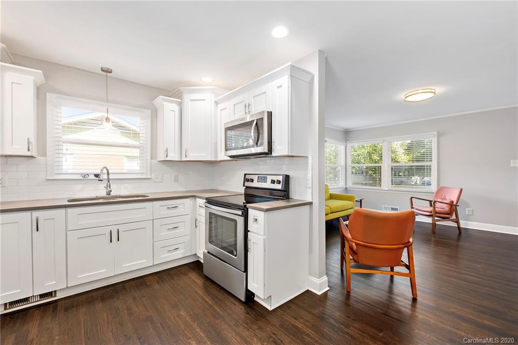 3115 Sudbury Road Charlotte, NC 28205 - Photo 6 of 17 a kitchen with stainless steel appliances granite countertop wooden floors and white cabinets