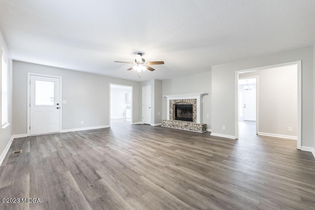 1734 Dixon Road Roberta, GA 31078 - Photo 17 of 40 an empty room with wooden floor and fireplace