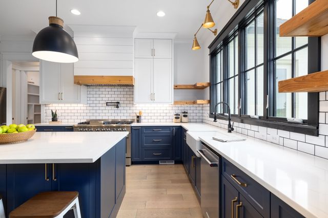 a kitchen with kitchen island granite countertop a sink stove and wooden floor