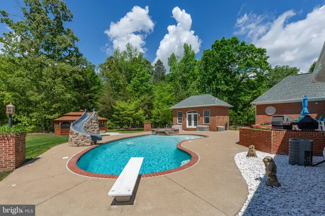 a front view of a house with a large tree