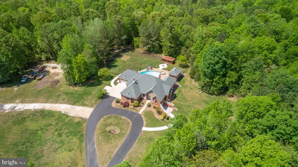 an aerial view of a house with a yard swimming pool and outdoor seating