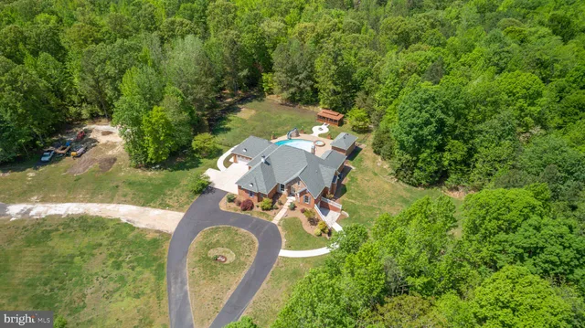 an aerial view of a house with a yard swimming pool and outdoor seating