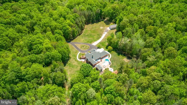a house view with swimming pool in front of it