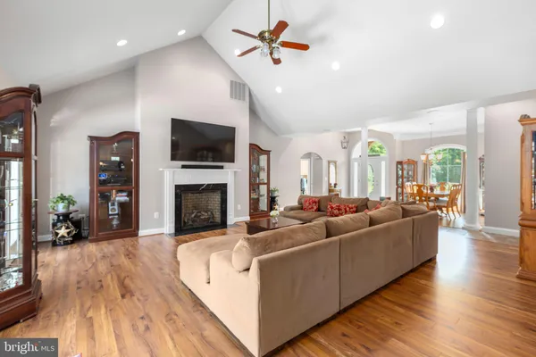 a dining room with wooden floor a chandelier a wooden table and chairs