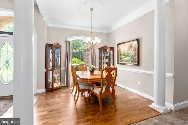 a kitchen with stainless steel appliances kitchen island granite countertop a refrigerator and a stove top oven with wooden floor