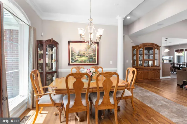 an empty room with a chandelier fan and windows