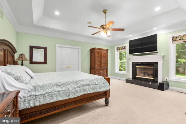a view of a swimming pool with a lounge chair and trees in the background