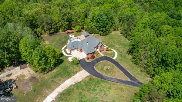 an aerial view of a house with a yard and lake view
