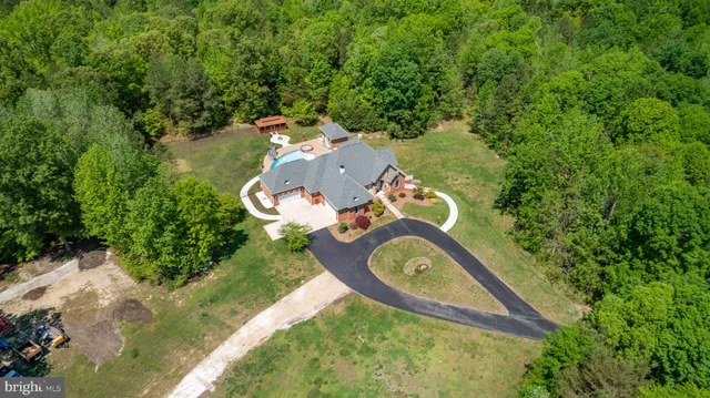 an aerial view of a house with a yard and lake view